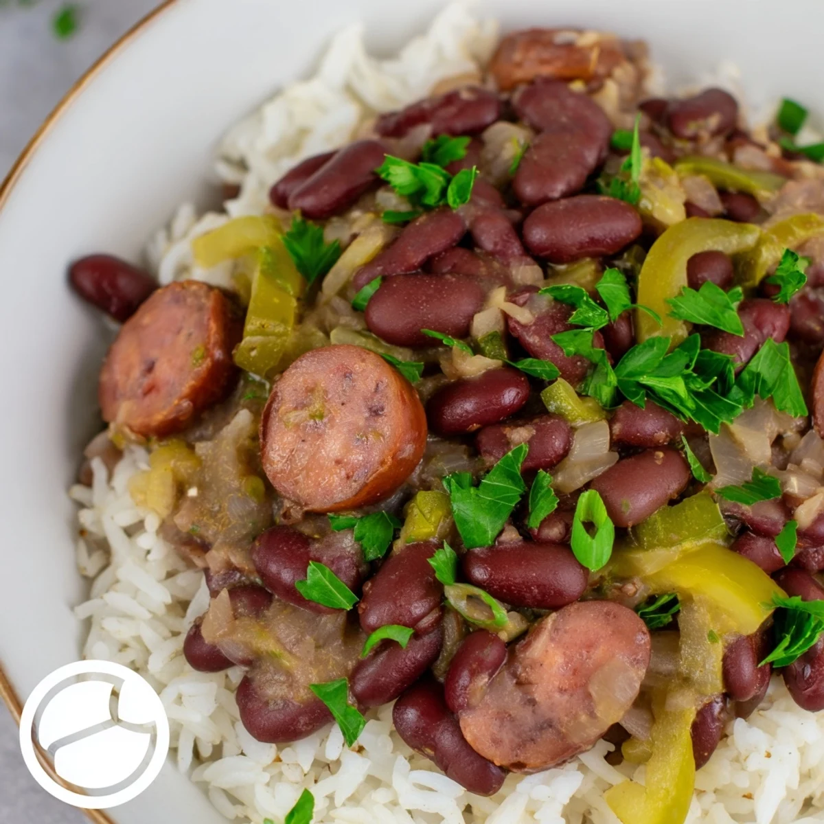 A close-up of simmering New Orleans Red Beans and Rice, featuring tender beans, savory sausage, and aromatic Creole spices.