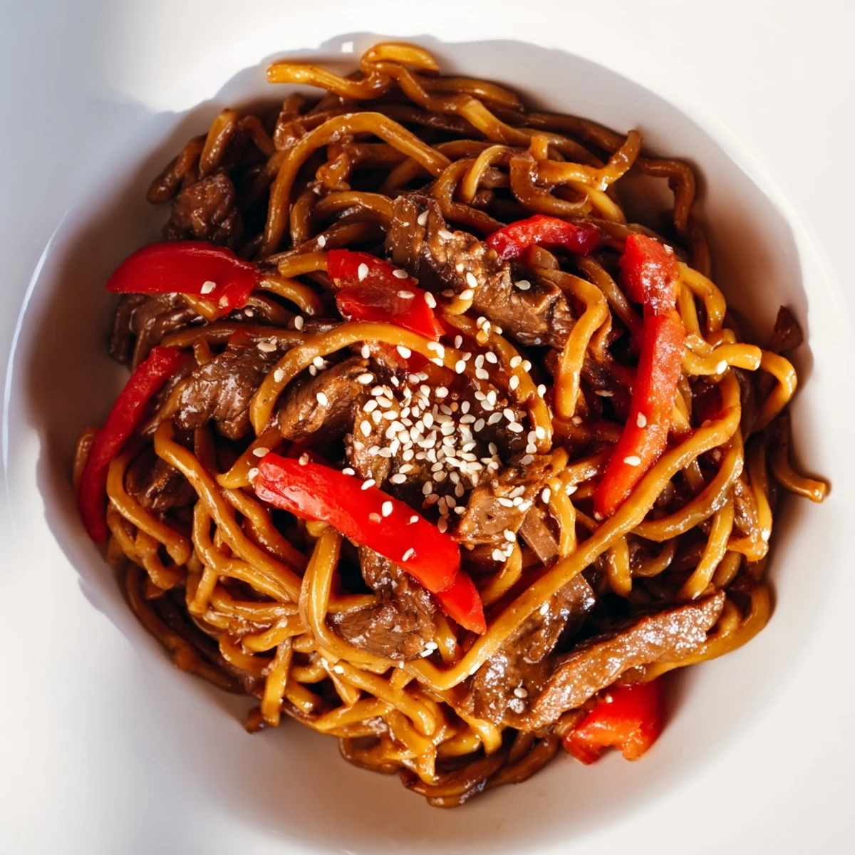 Tender beef strips and crisp bell peppers are tossed with chewy noodles in a vibrant, spicy sauce.