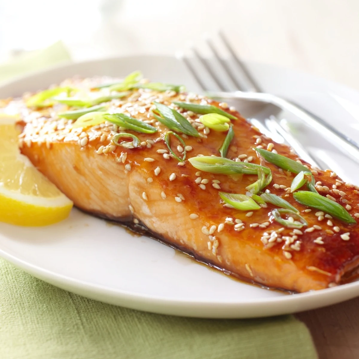 Flaky, oven-roasted Baked Salmon with Teriyaki Glaze, topped with toasted sesame seeds and sliced green onions for an easy weeknight meal.