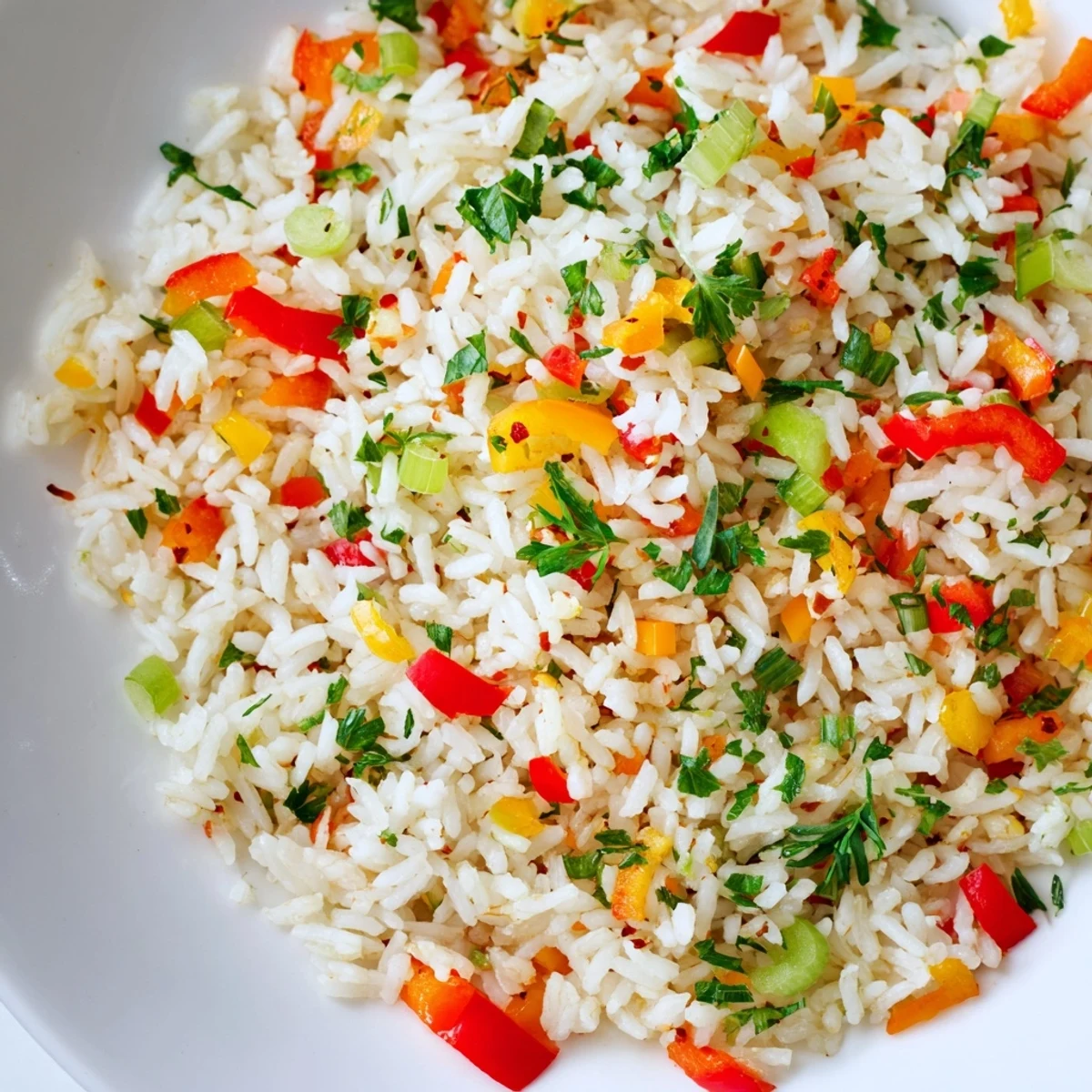 A close-up of Creole Rice Pilaf with Peppers showing fluffy, golden rice studded with vibrant red and green bell peppers and fresh parsley garnish.
