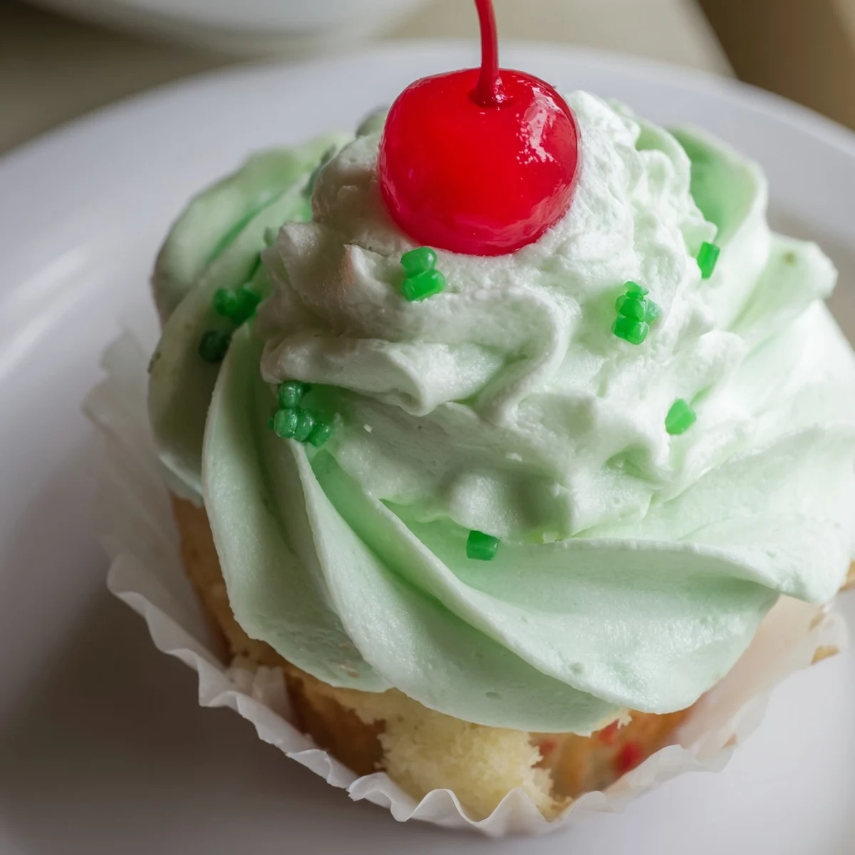 Green Shamrock Shake Cupcakes topped with fluffy whipped cream frosting and festive sprinkles.