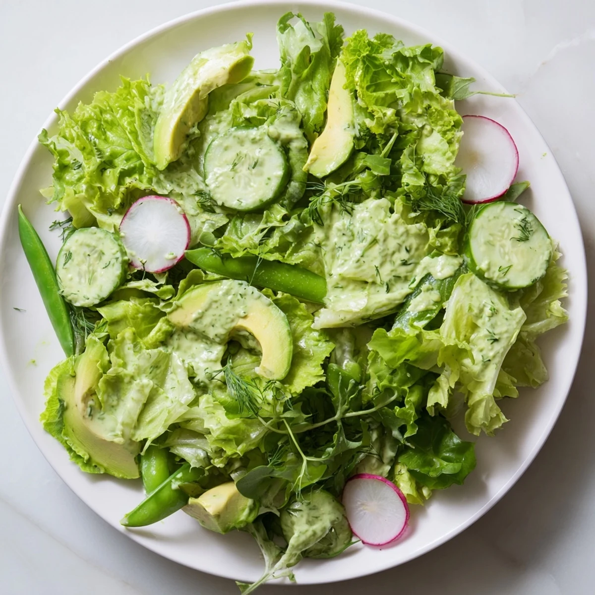 Overhead view of Green Salad with Green Goddess Dressing, a vibrant bowl of greens tossed in herbaceous dressing for a light meal.