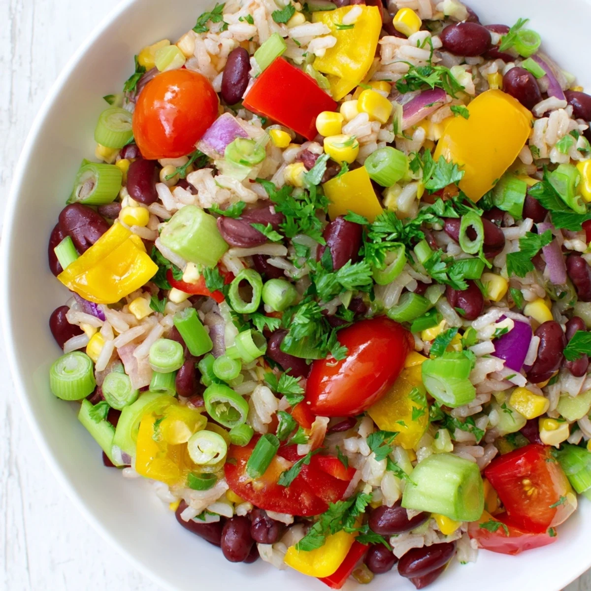 Colorful Mardi Gras Veggie Rice Bowl served with lime wedges and hot sauce.