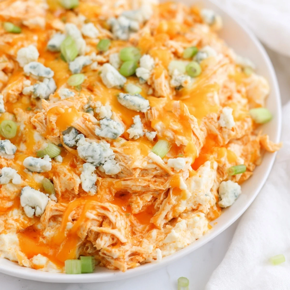 Appetizer platter featuring Keto Buffalo Chicken Dip alongside cucumber slices and keto-friendly crackers for dipping.