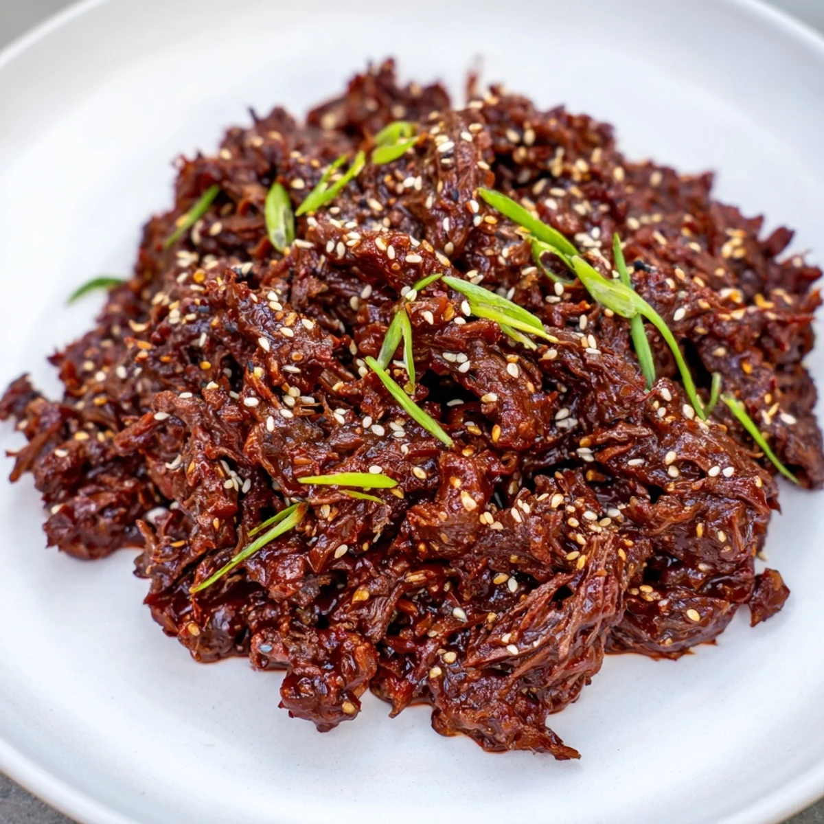 A slow cooker Korean beef stew simmered until fork-tender, served with steamed vegetables and garnished with red chili slices.