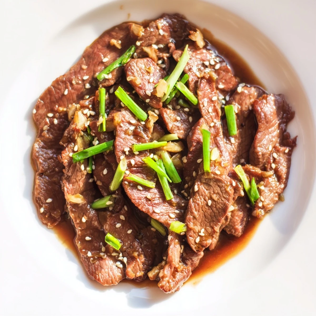 Tender beef slices in the Ultimate Slow Cooker Mongolian Beef recipe with a rich glaze and toasted sesame seeds.