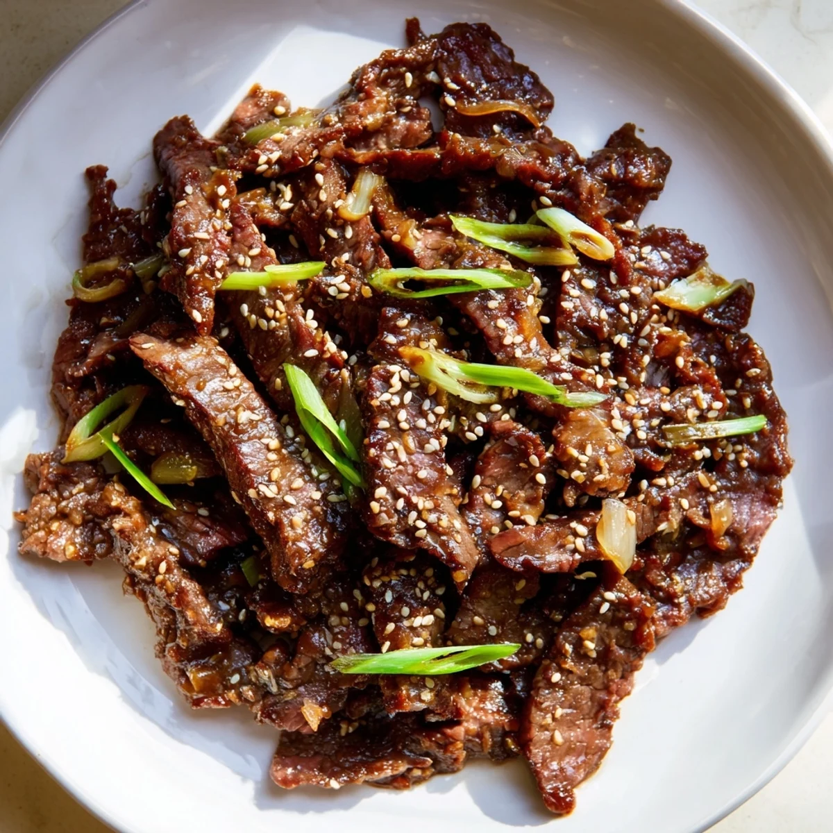 Steamed rice and broccoli alongside tender beef strips coated in rich slow cooker Mongolian Beef.