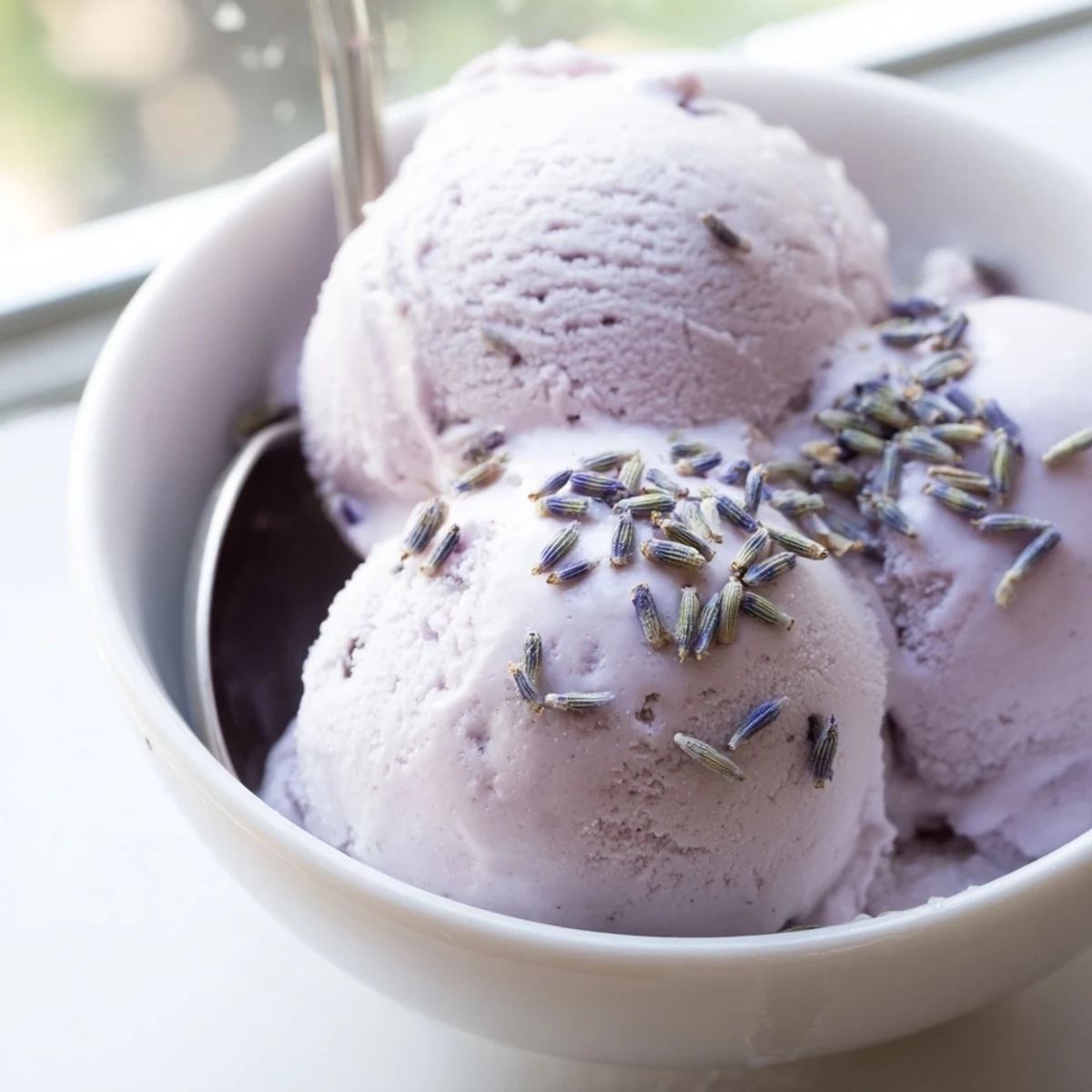 A dessert bowl filled with fragrant Lavender Ice Cream, paired with fresh berries for a refreshing summer treat.