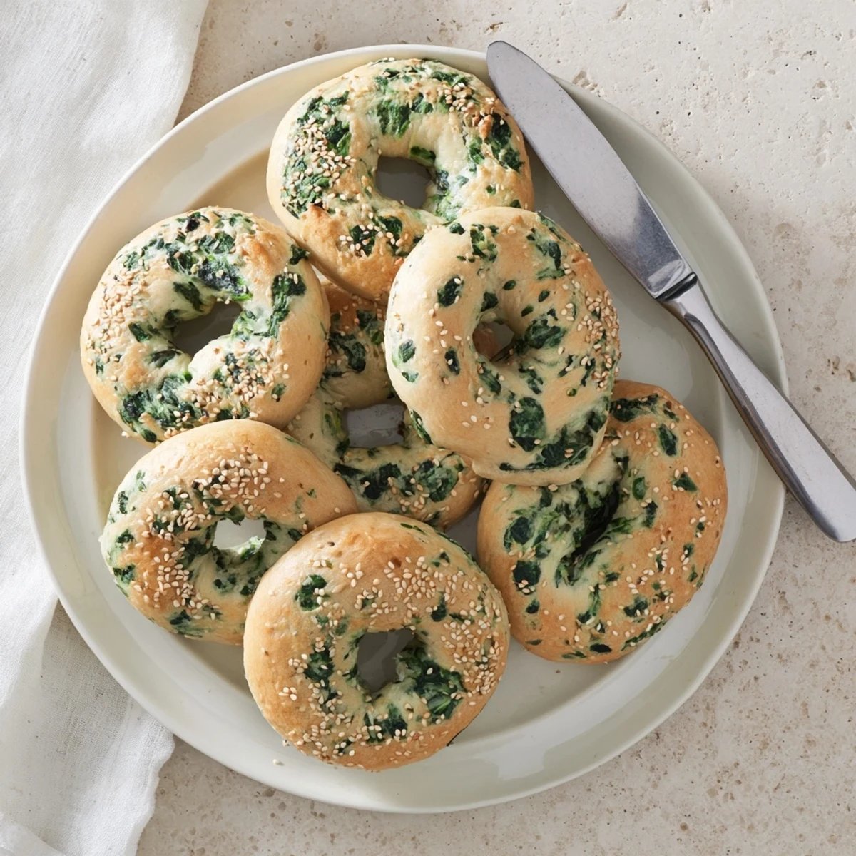 A close-up of a halved Spinach Cottage Cheese Flagel, revealing the tender green-flecked crumb inside.