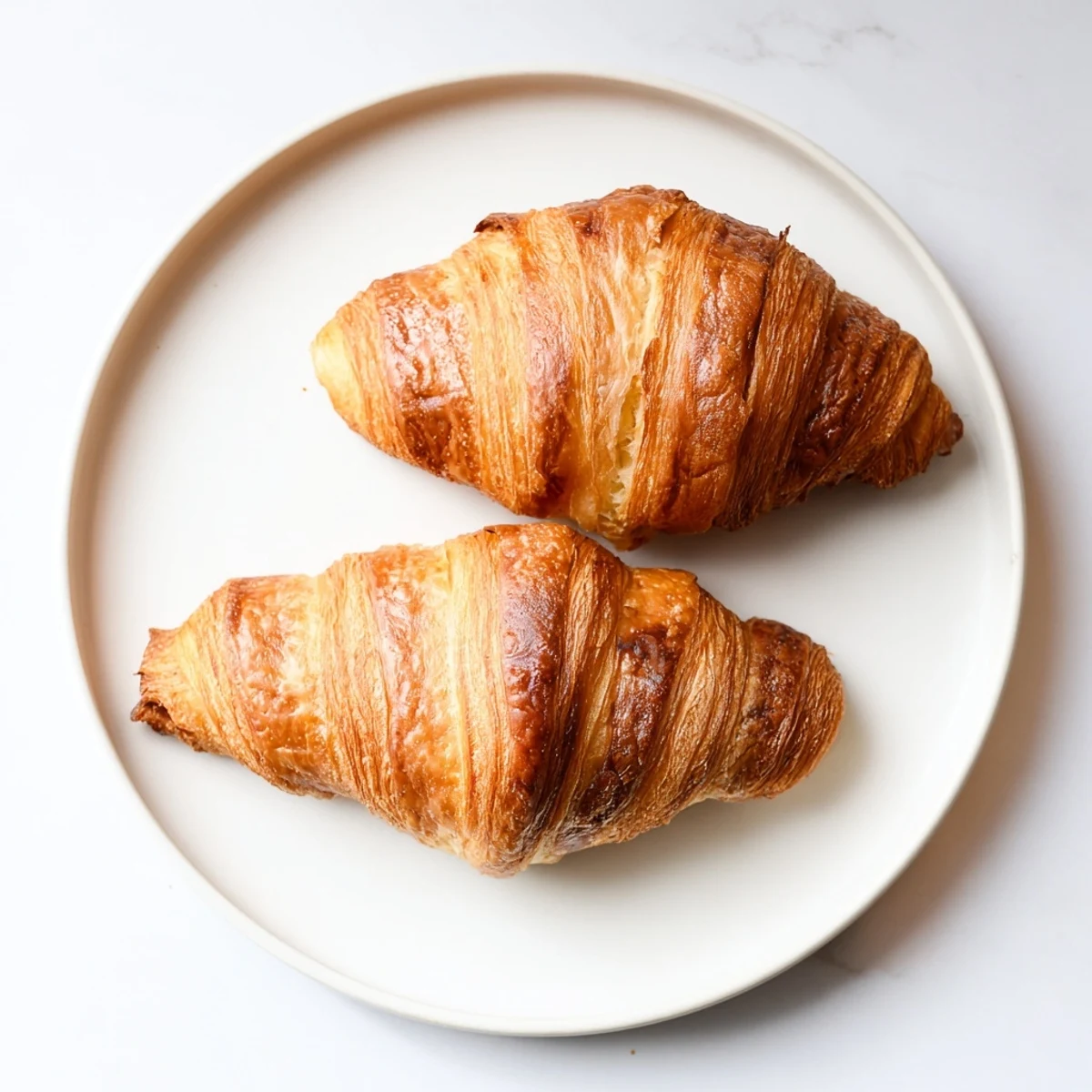 Freshly baked gluten-free croissants on a rustic wooden board, golden and flaky.