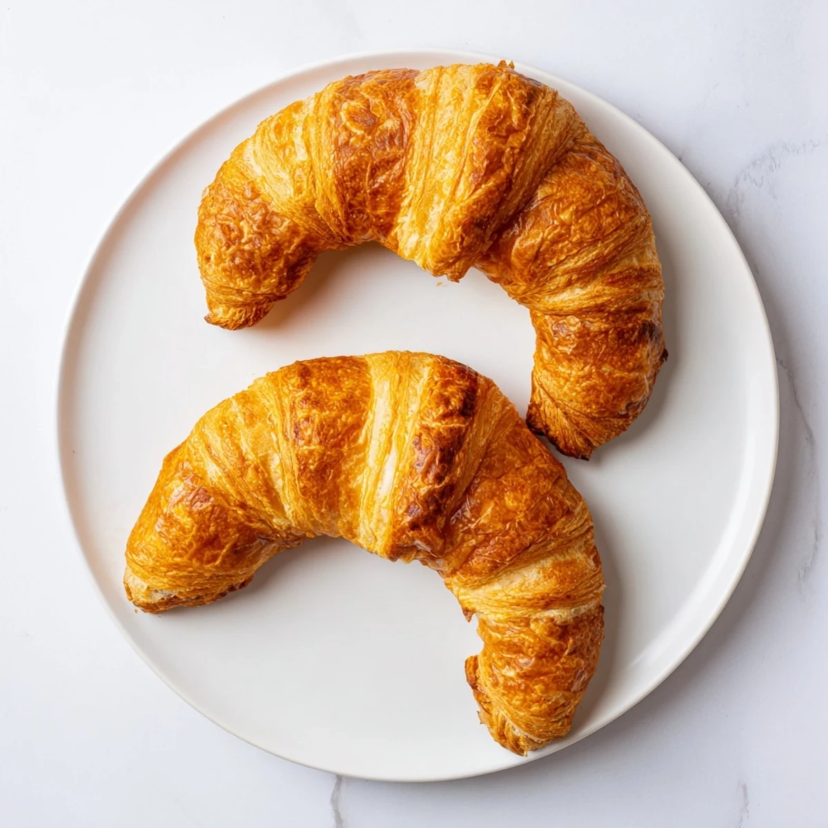 Gluten-free croissants layered with butter, served warm with a dollop of jam.
