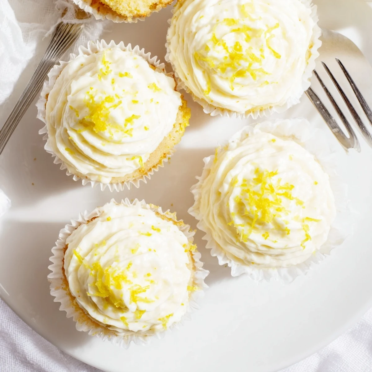Delicious Limoncello Cupcakes with creamy frosting and bright lemon zest on a marble counter.