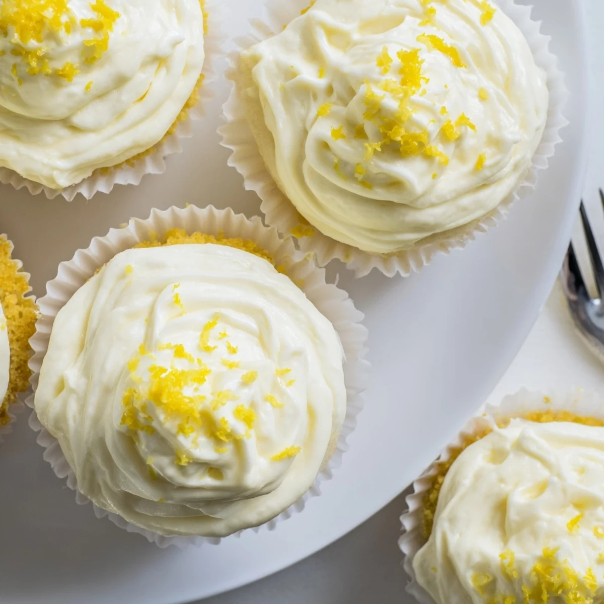 Moist Limoncello Cupcakes topped with fluffy frosting and fresh lemon zest for summer gatherings.