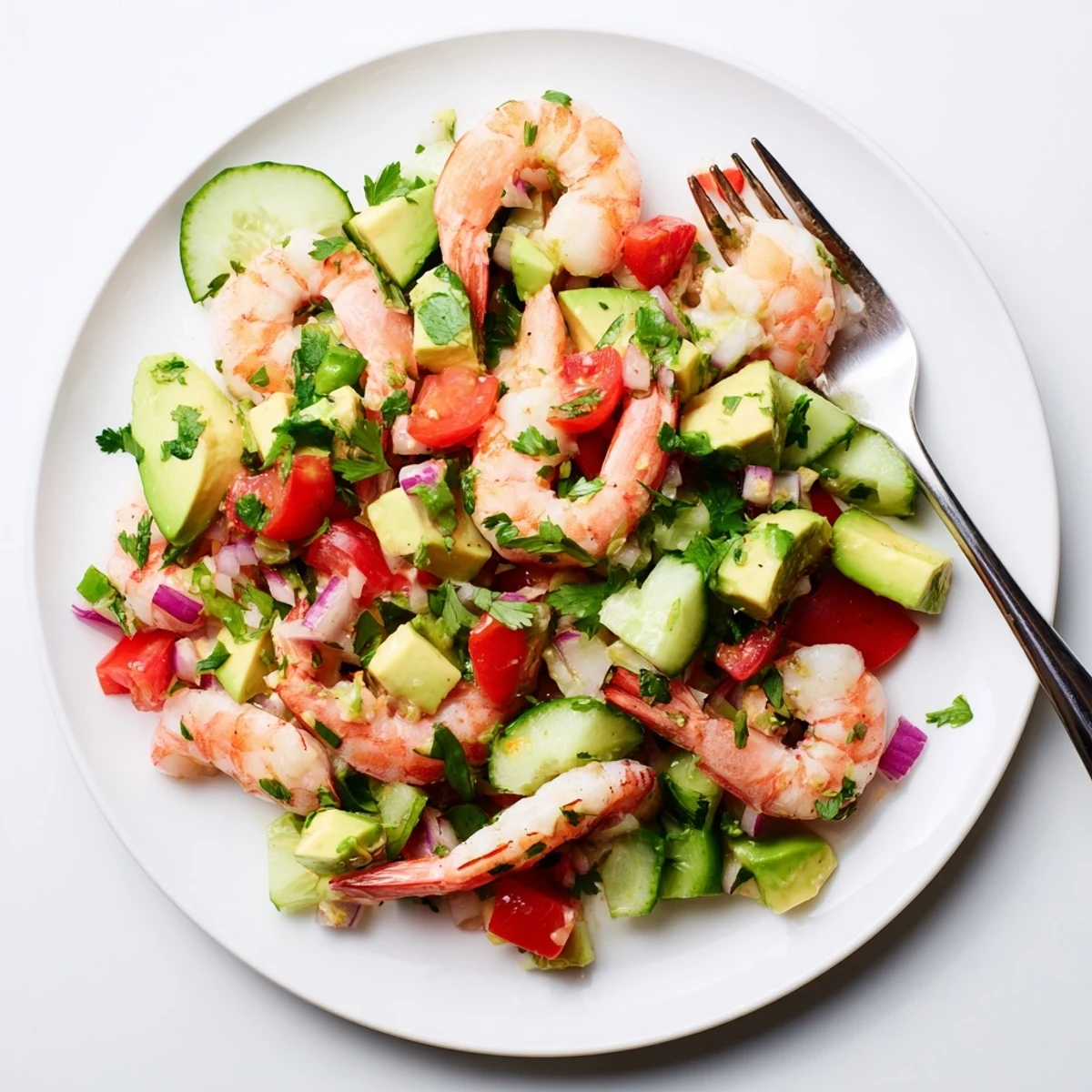 Freshly cooked shrimp are tossed with diced avocado, cherry tomatoes, and cucumber in this Healthy Shrimp Avocado Salad.