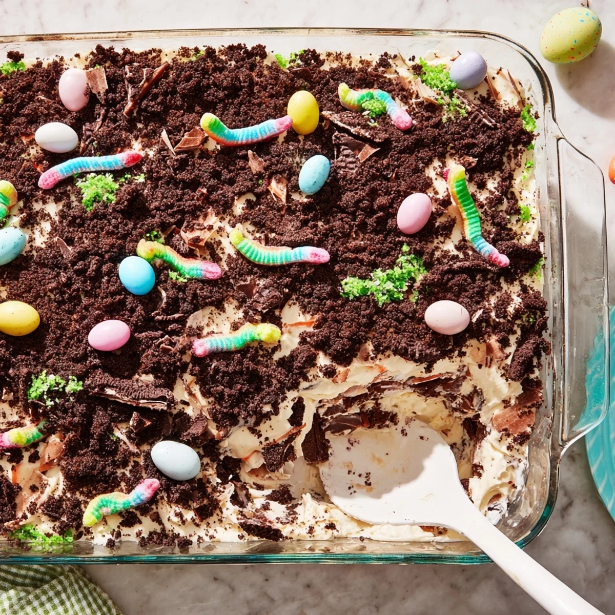 No-bake Easter Dirt Cake casserole served in a glass dish with playful gummy worm garnish