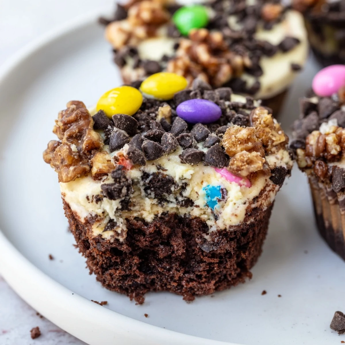 Individual loaded brownie cheesecake cups featuring swirled chocolate and vanilla layers with sprinkles