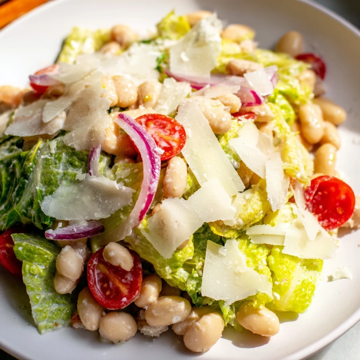 Protein-packed butter bean Caesar salad featuring crisp lettuce, red onion, and creamy dressing