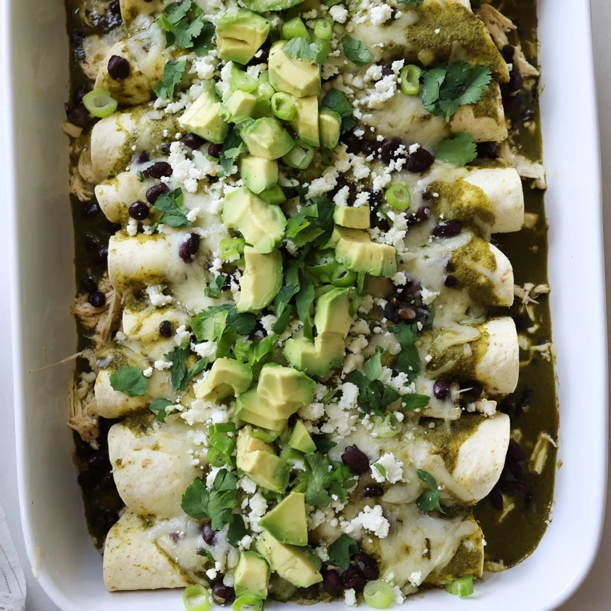 Golden chicken enchiladas smothered in vibrant green salsa verde and bubbling melted cheese