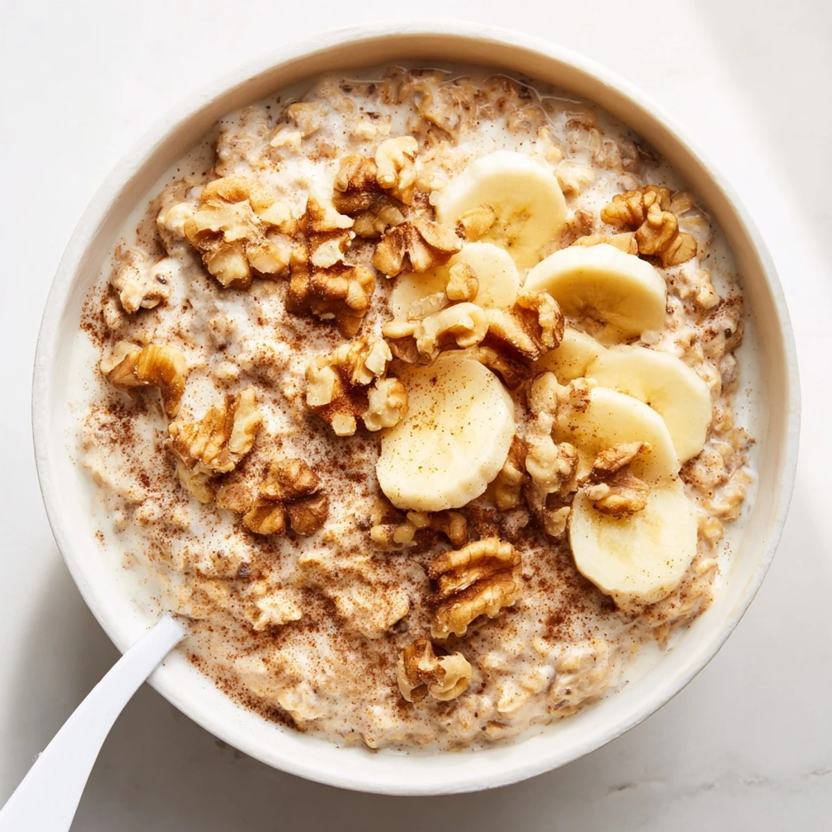 Glass jar of brown sugar overnight oats topped with fresh banana slices and chopped walnuts