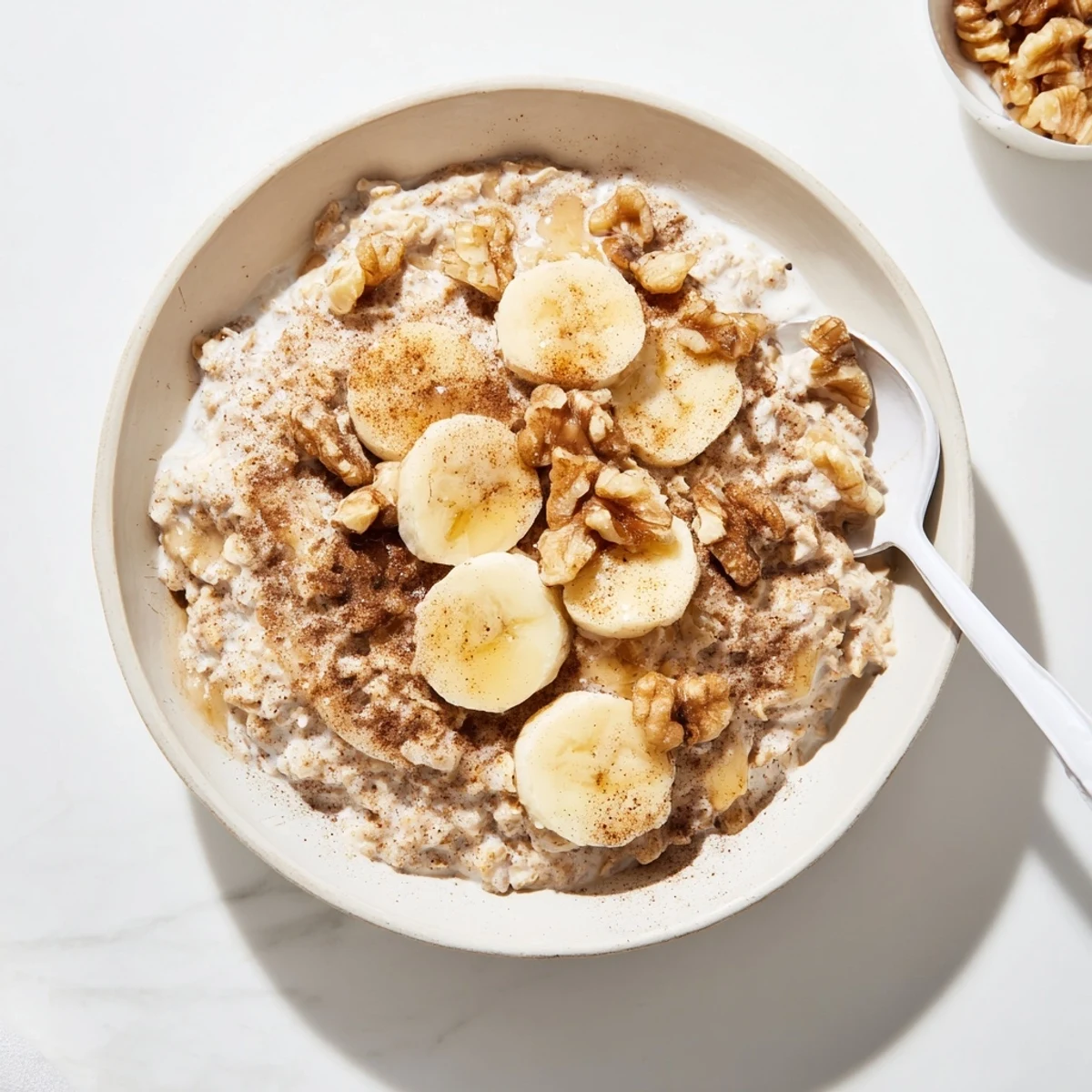 Creamy brown sugar overnight oats in a white bowl with cinnamon and vanilla layers