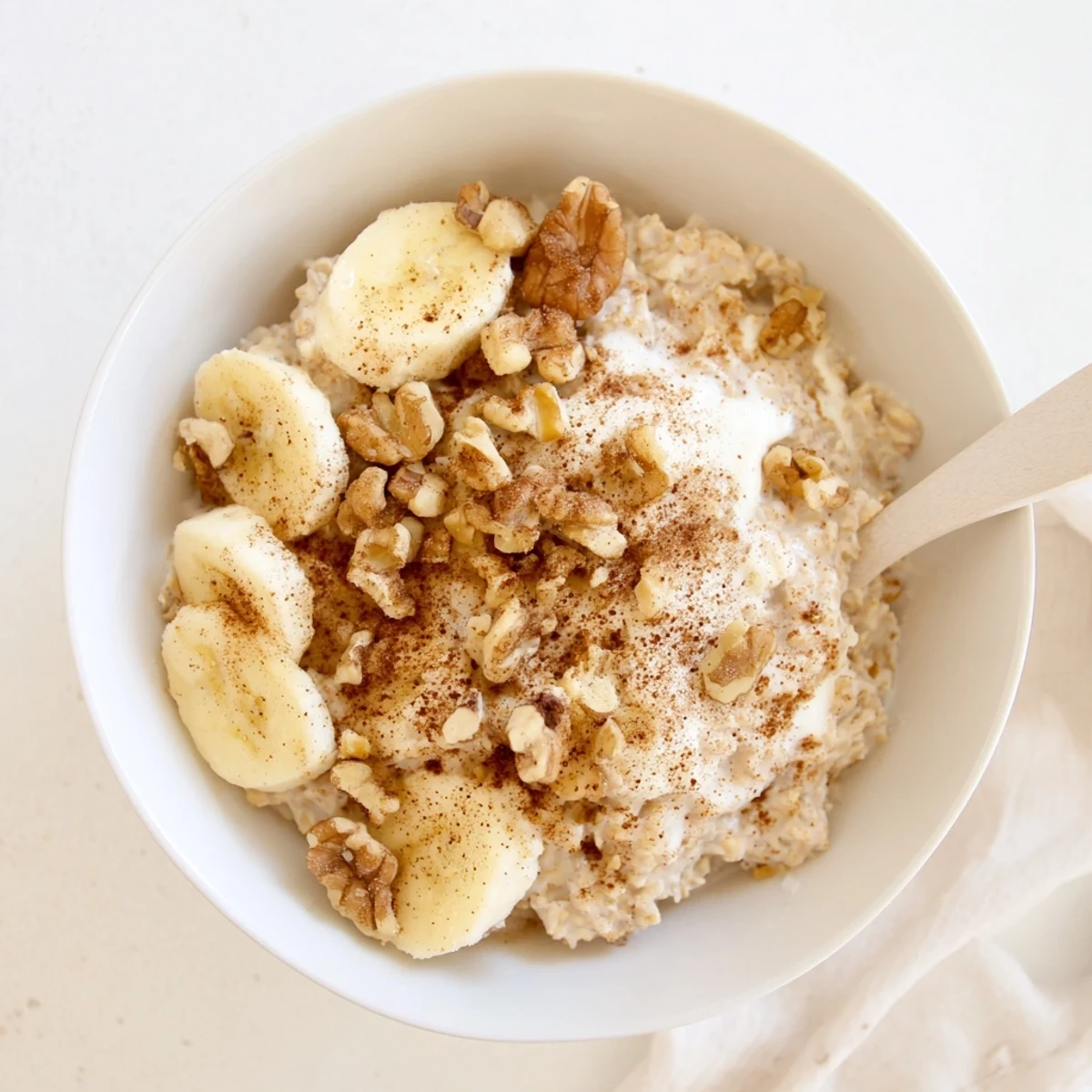 Spoonful of chilled brown sugar overnight oats with berries and pecans on a wooden table