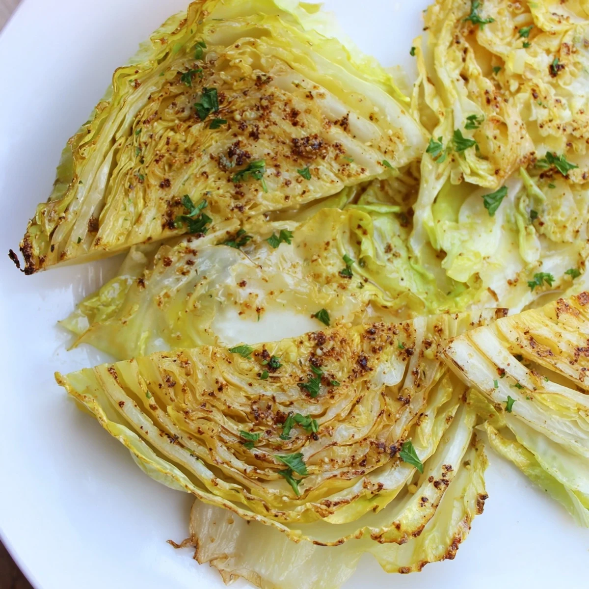 Thick slices of green cabbage roasted to perfection with olive oil and spices on a baking sheet