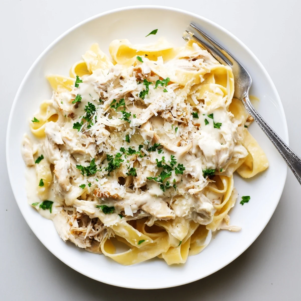 Creamy Crock Pot Chicken Alfredo with tender shredded fettuccine in rich white sauce