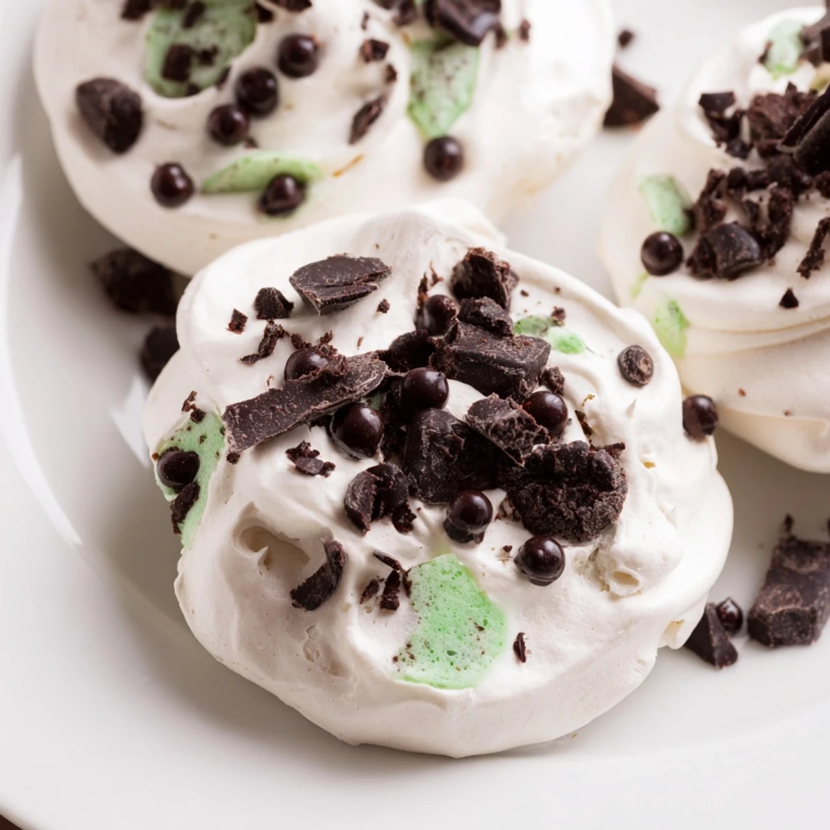 Airy dark chocolate mint chip clouds showing glossy meringue texture with speckled chocolate chips