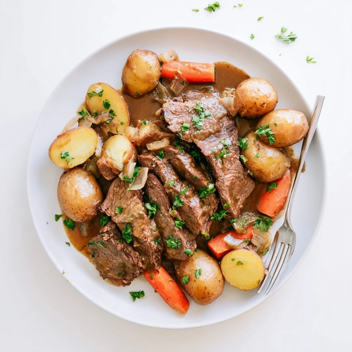 Fork-tender French onion pot roast served with baby potatoes and melted Gruyère cheese on top