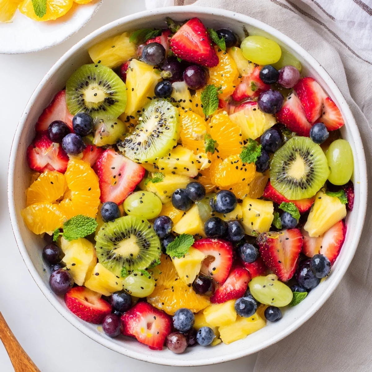 Refreshing Easter fruit salad featuring honey lime dressing drizzled over vibrant mixed spring fruits