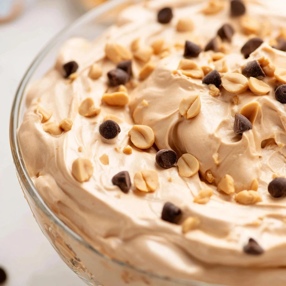 Creamy peanut butter and Cool Whip mousse topped with chocolate chips in clear glass
