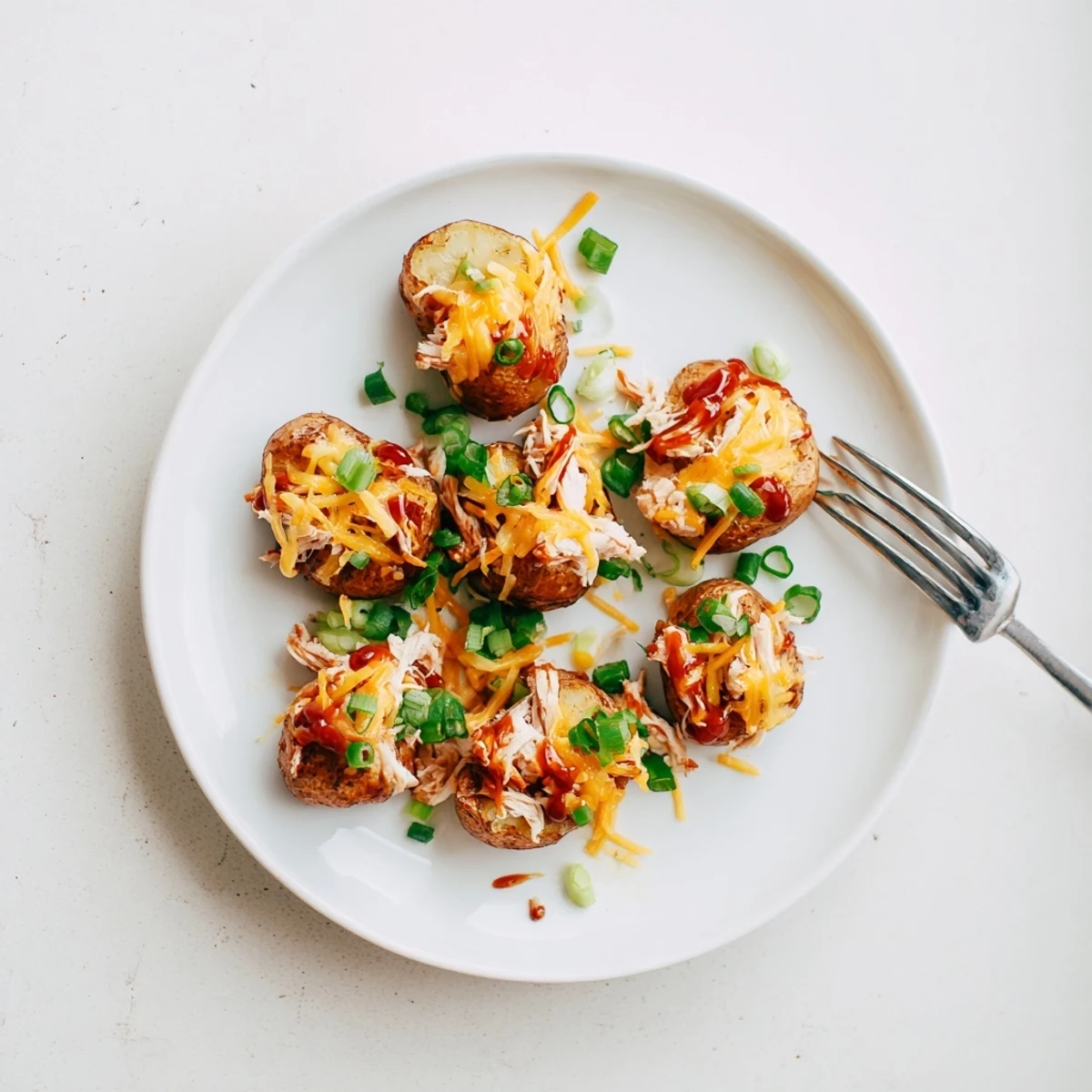 Sliced honey BBQ chicken draped over crispy potatoes with bubbling cheese and green onions