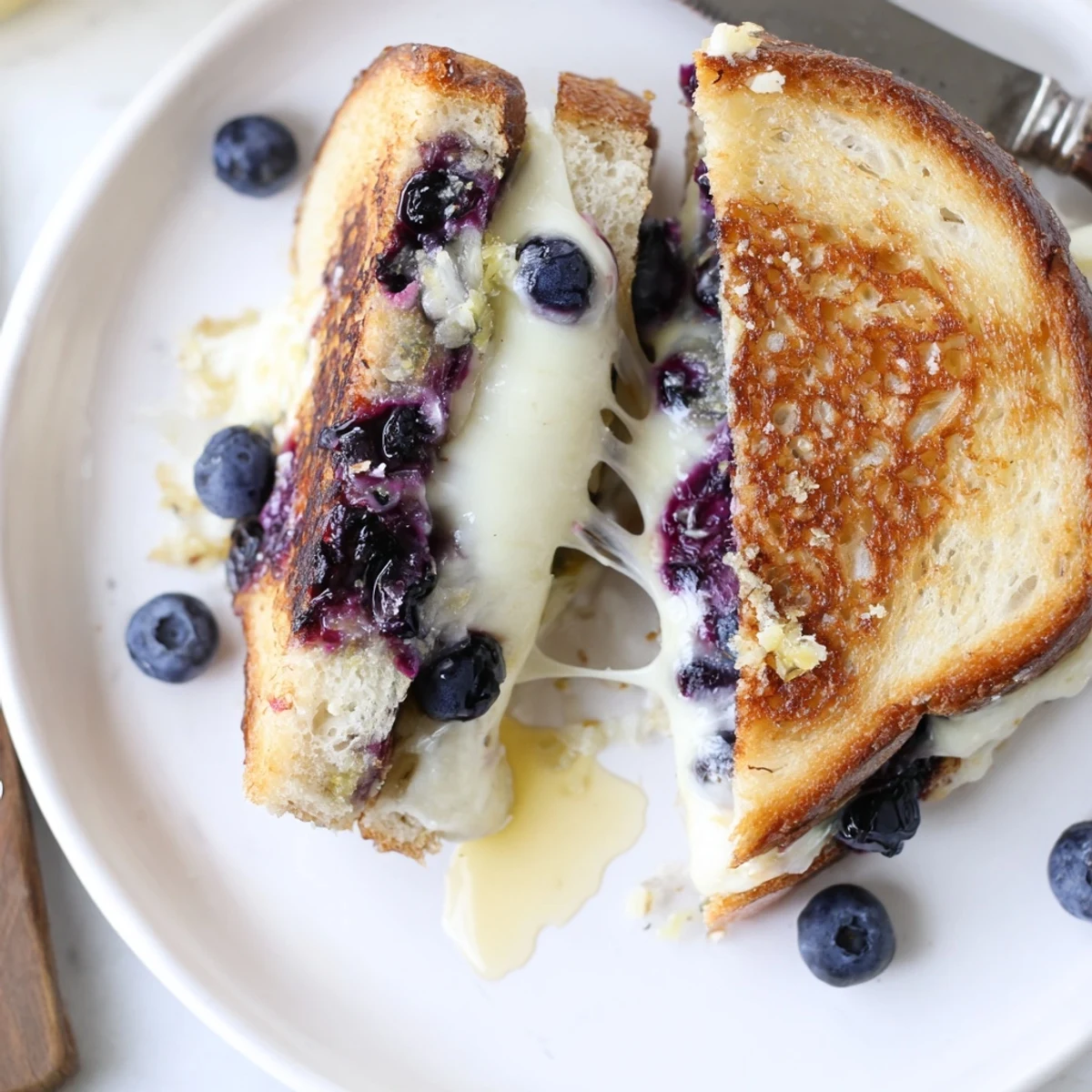 Buttery skillet toast reveals Juicy Blueberry Grilled Cheese oozing warm creaminess  