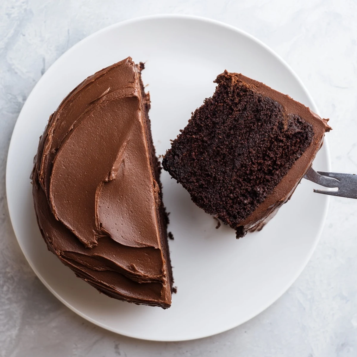 Homemade Matildas chocolate cake served on a white plate with a fork ready for birthday celebrations
