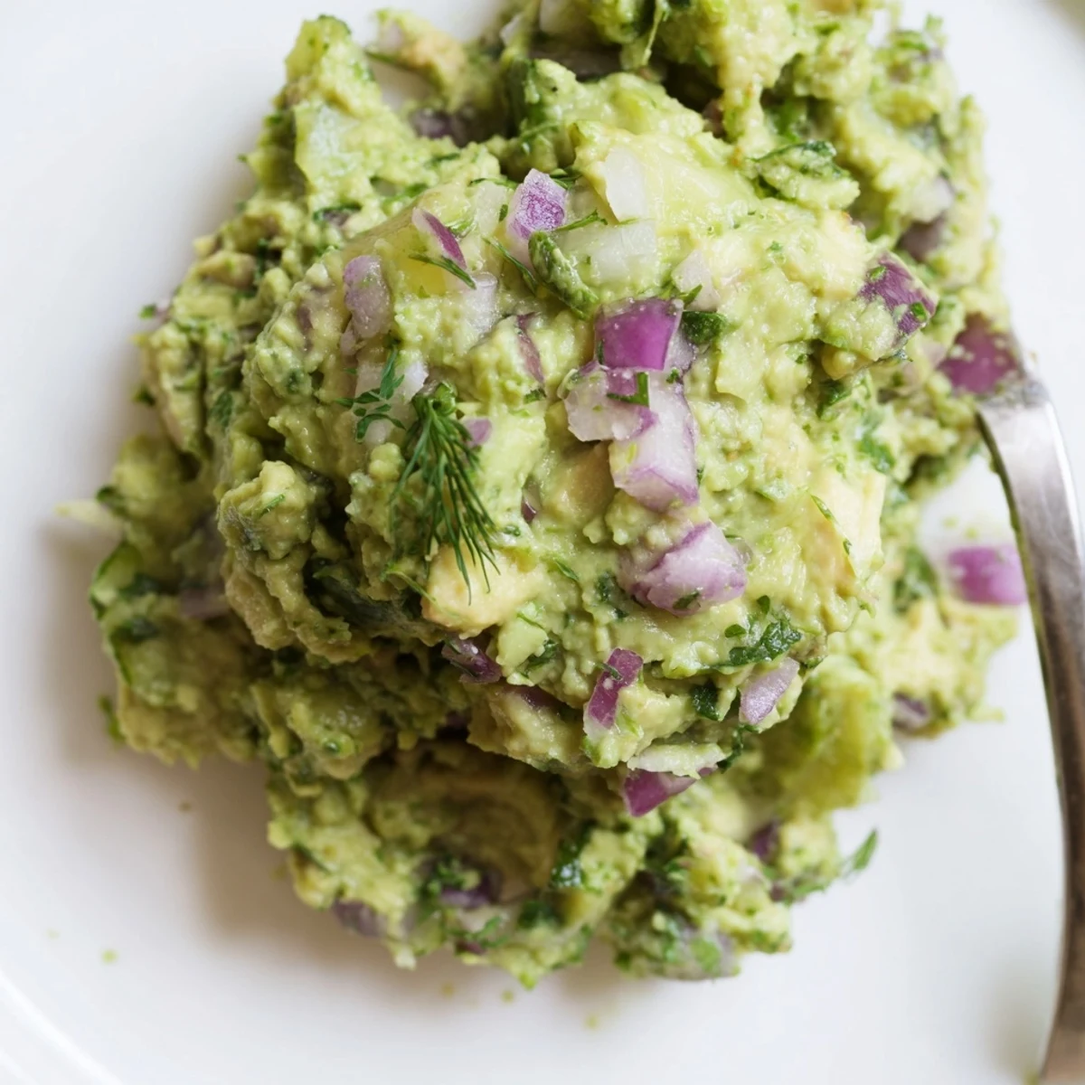 Tangy, creamy Smashed Chickpea Avocado Pickle spooned onto crackers for dipping