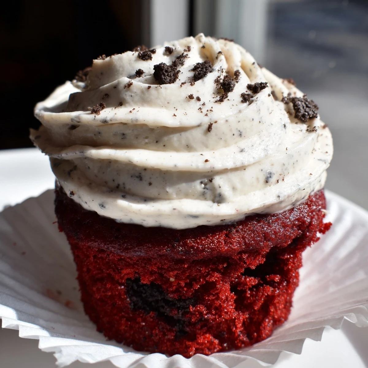 Moist Red Velvet Oreo Cupcakes with cookie crumb garnish displayed on a white cake stand