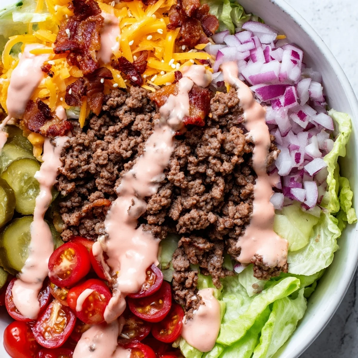 Savory burger bowls drizzled with creamy homemade sauce and topped with bacon