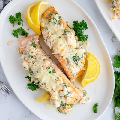 Close-up of a fork flaking tender Crab & Shrimp Stuffed Salmon, revealing the creamy seafood filling with crab and shrimp chunks.