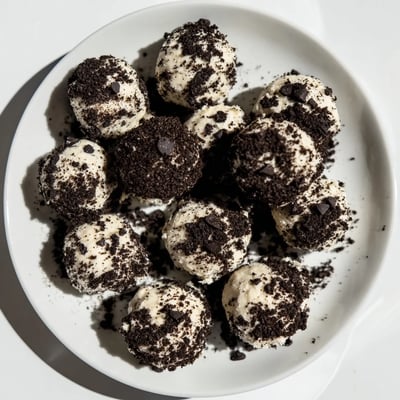Overhead view of Cream Cheese Oreo Protein Balls arranged on a parchment-lined tray, perfect for a quick post-workout snack.
