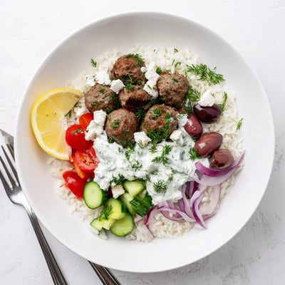 Juicy lamb Greek meatball bowl served over rice with cool tzatziki drizzle