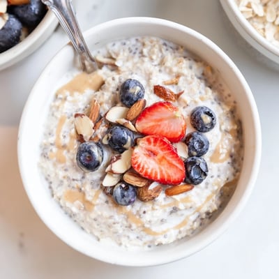 Chilled Protein Overnight Oats spoon ready, vanilla scented, with a nut butter swirl.